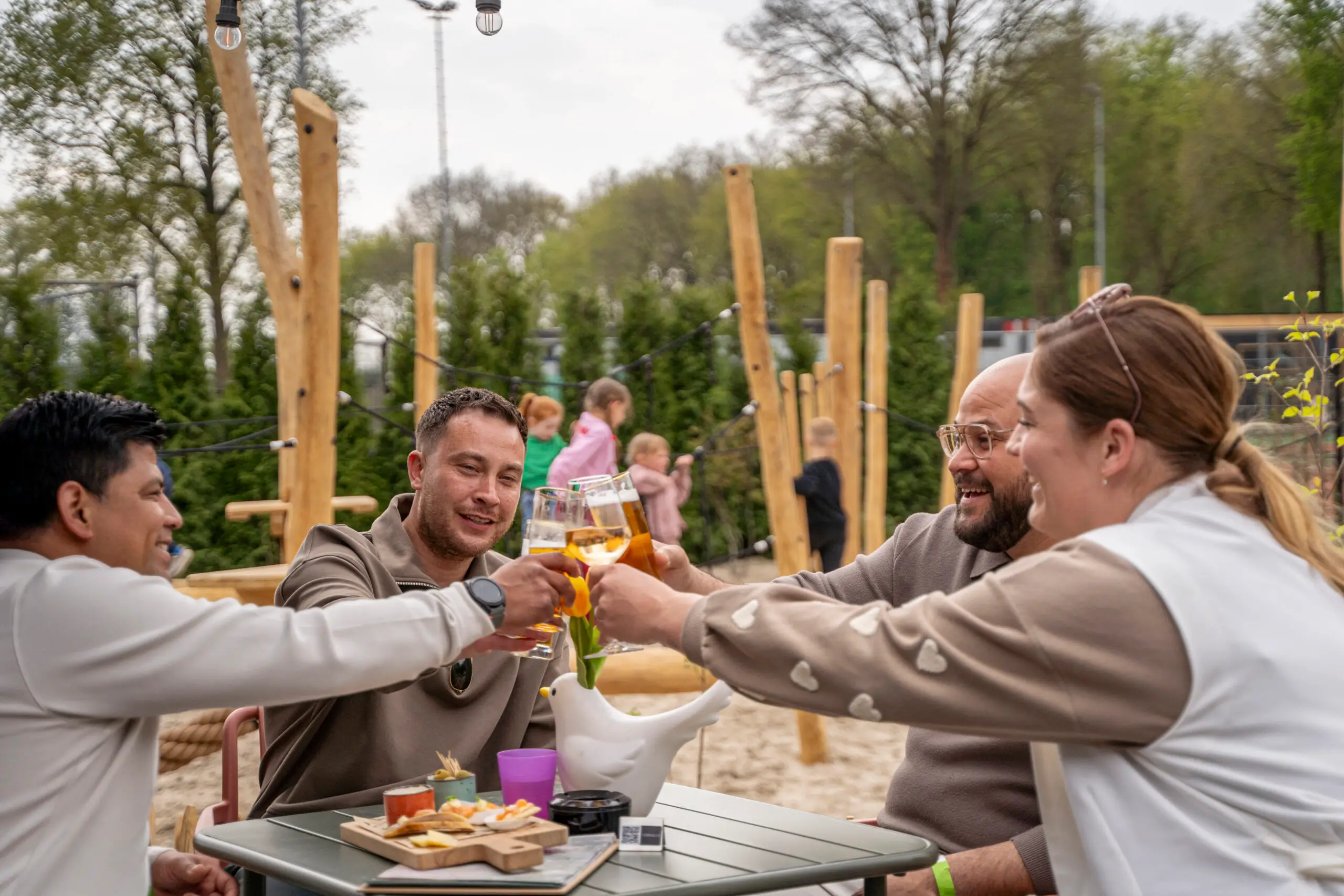 Vrienden die proosten op het terras van De Hoge Heide