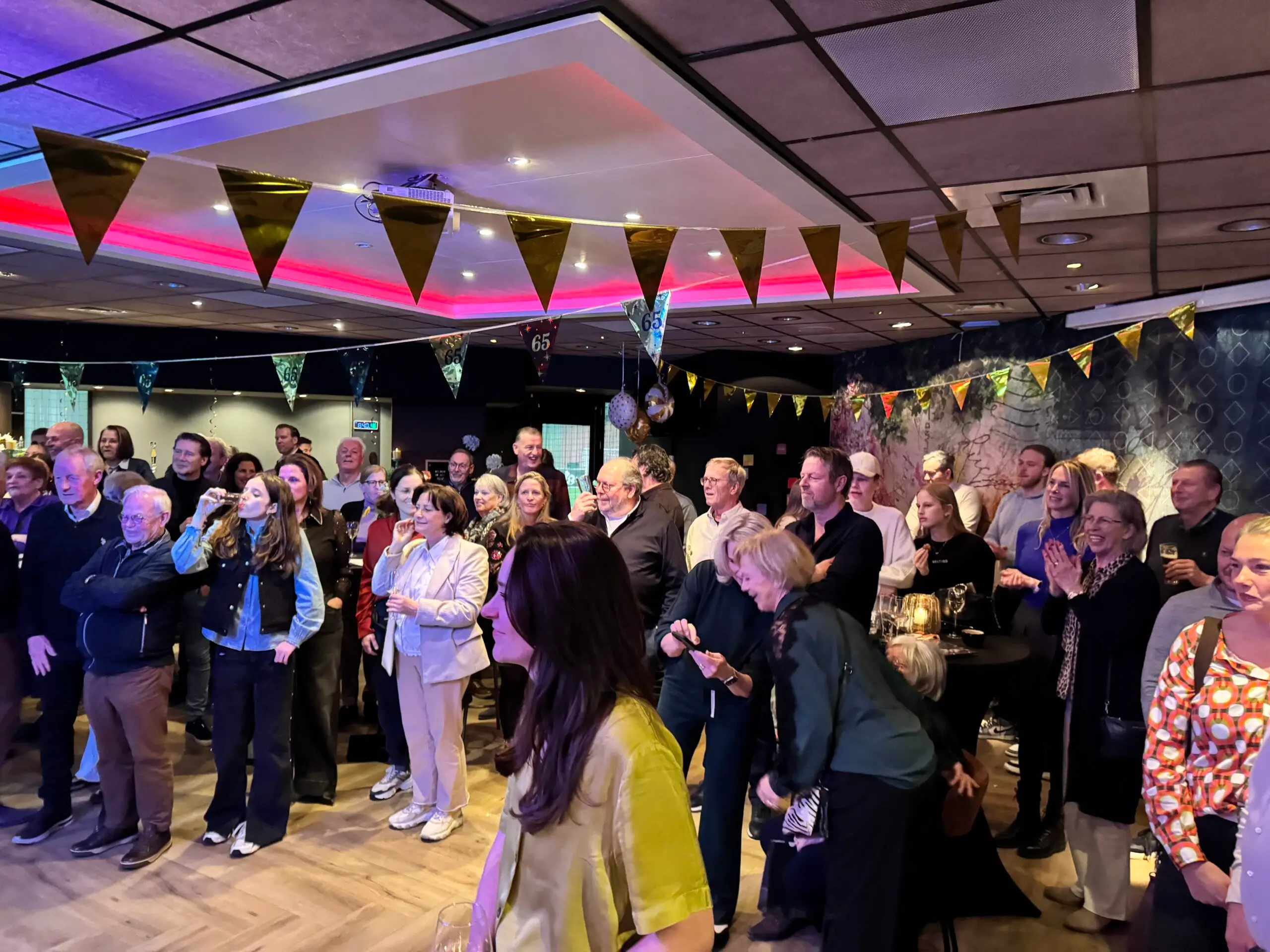 Grote groep mensen jong en oud op een feestje