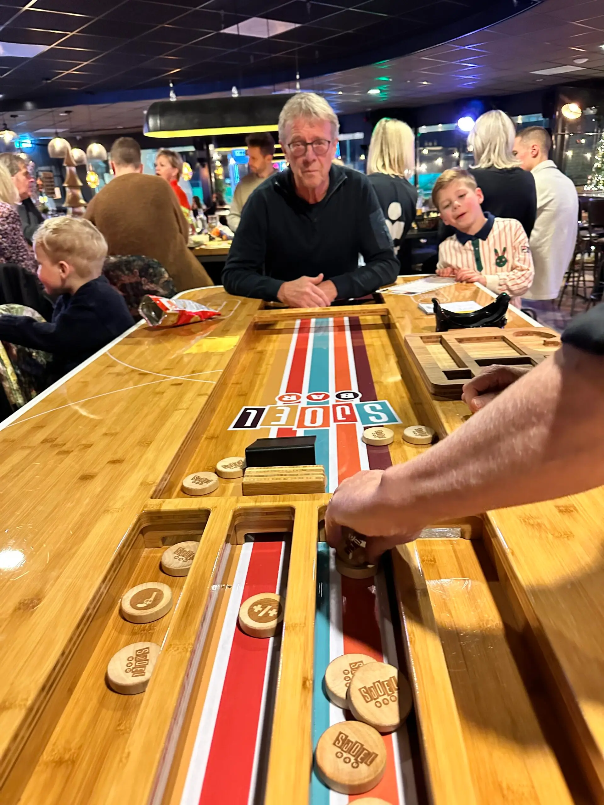 Jong en oud speelt aan de sjoelbar