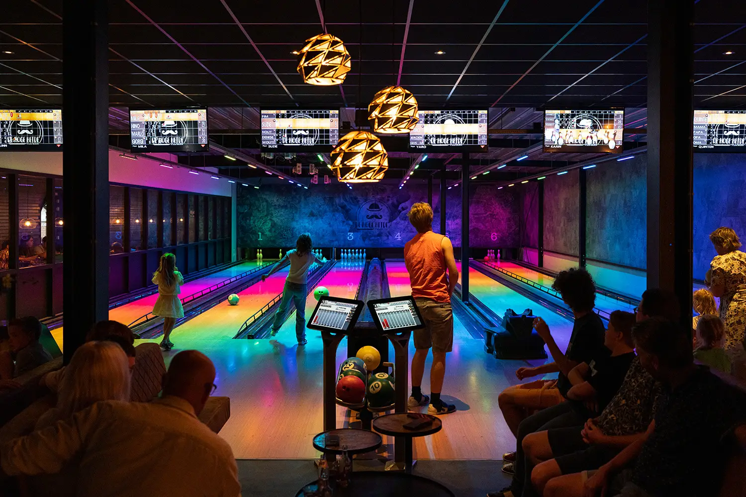 Kinderen en volwassenen op de bowlingbaan