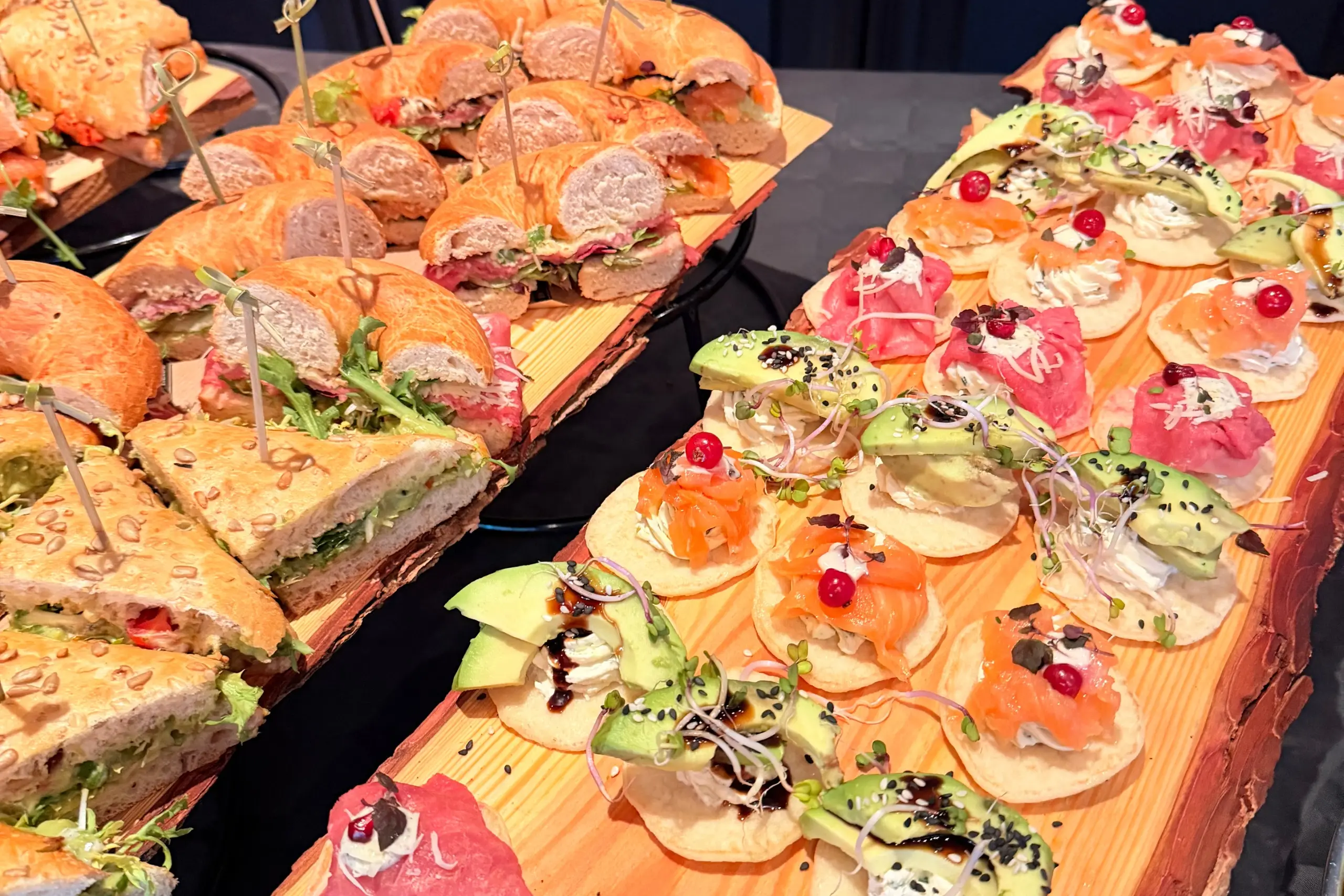 Close-up van luxe belegde broodjes en hartige hapjes met zalm, avocado en vleeswaren.